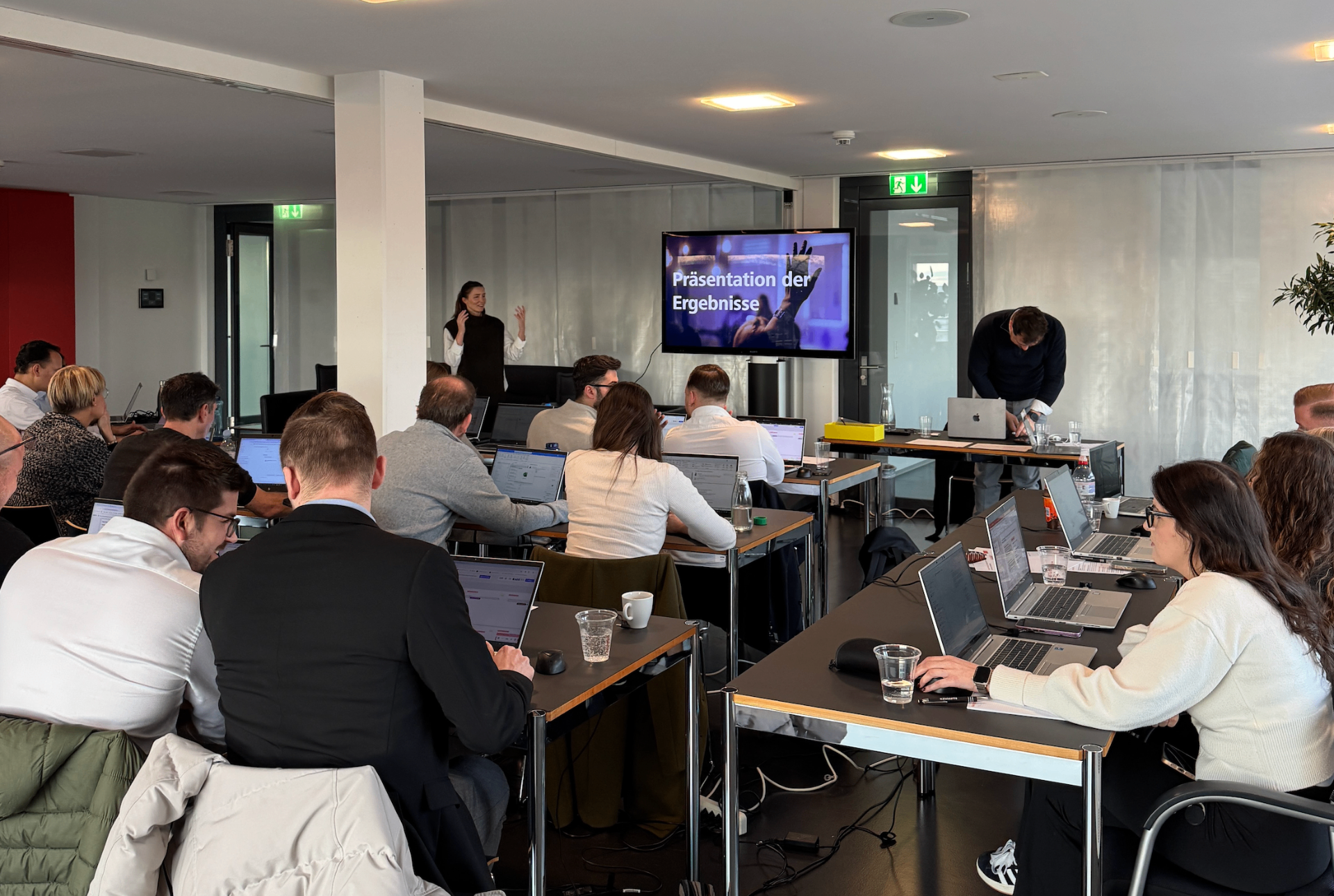 Speaker presenting GenAI training workshop to corporate audience with presentation slides